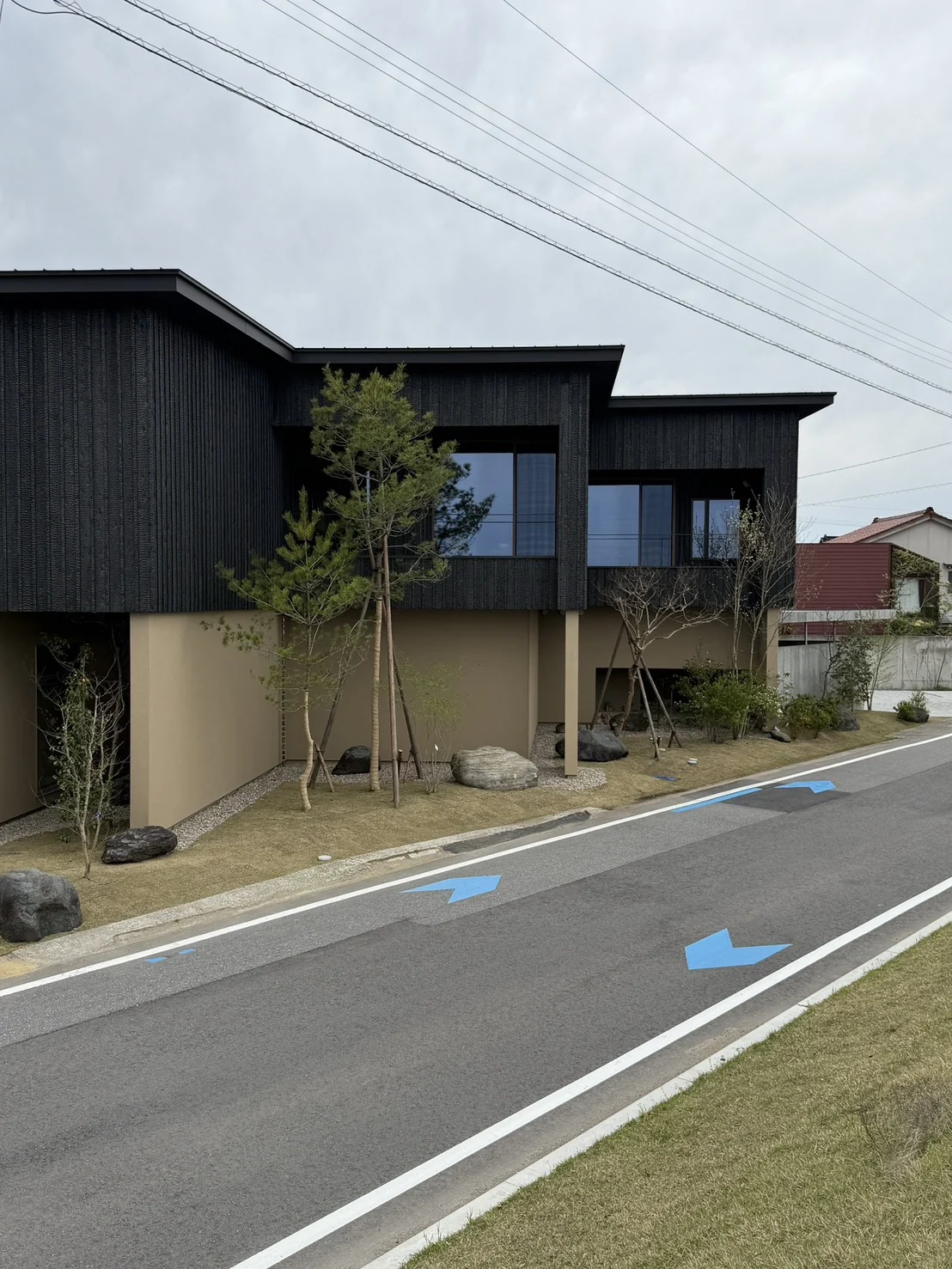 株式会社AiBAが手がけた黒い外壁と庭のある建物